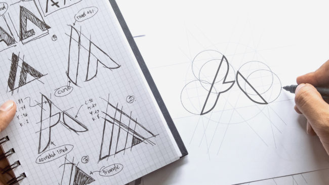 Sketching logo design ideas on notebook creative agency