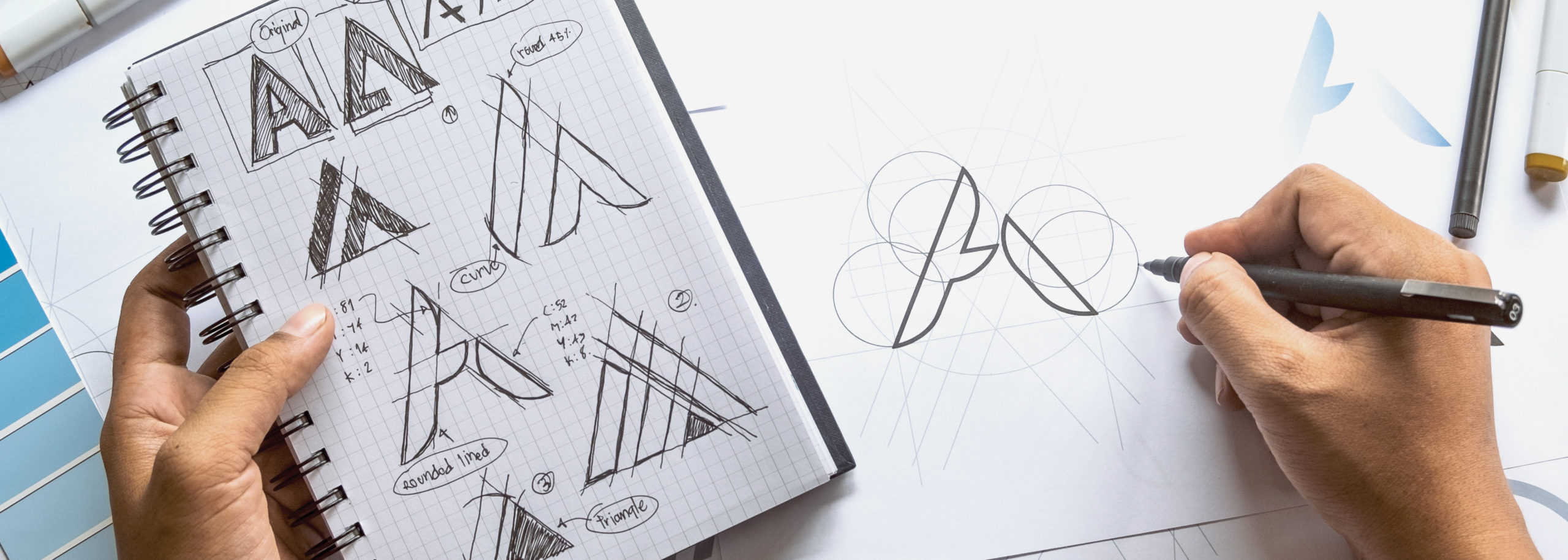 Sketching logo design ideas on notebook creative agency