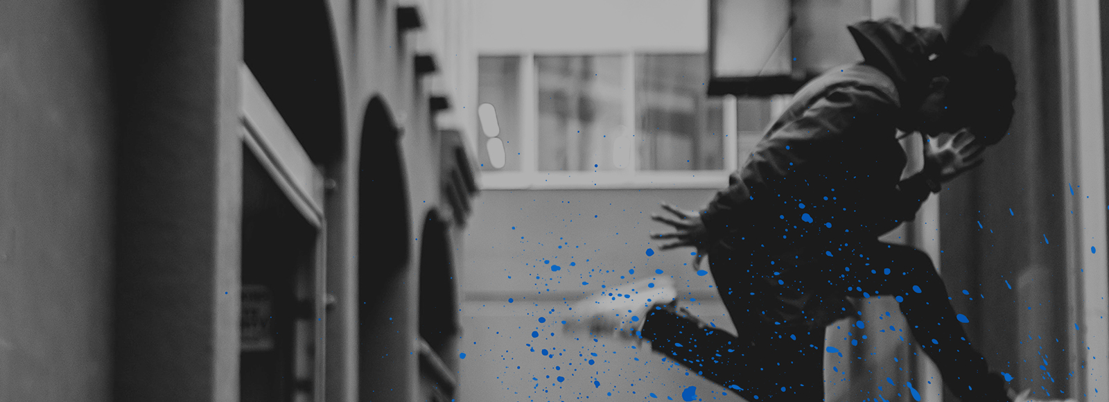 Black and white dancing man in street with a blue splatter paint