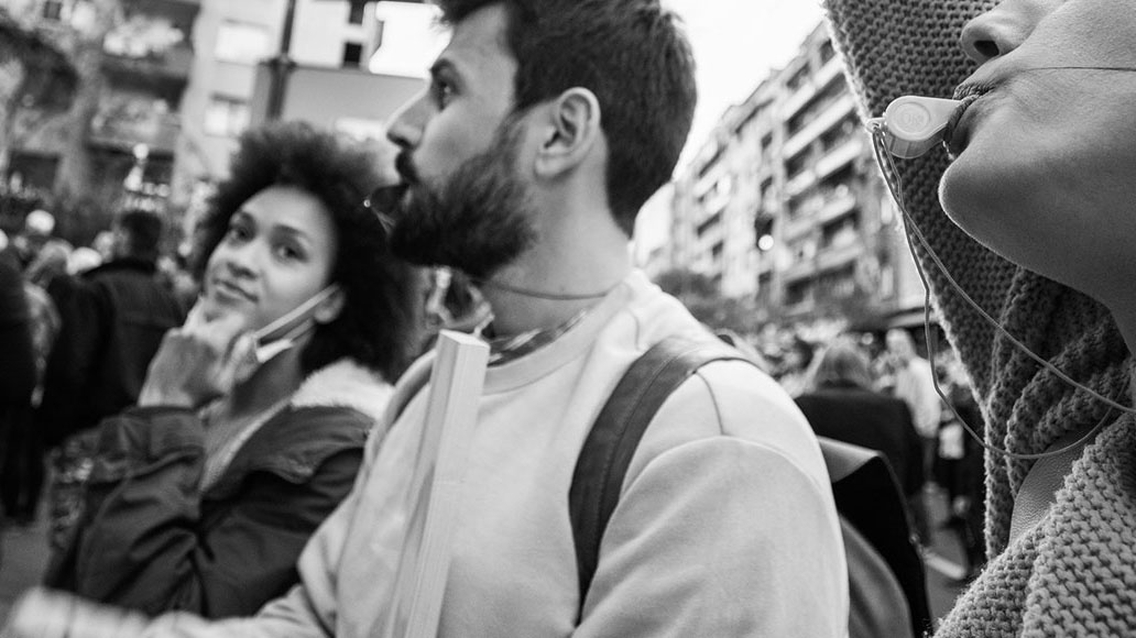 protester blowing a whistle in black and white