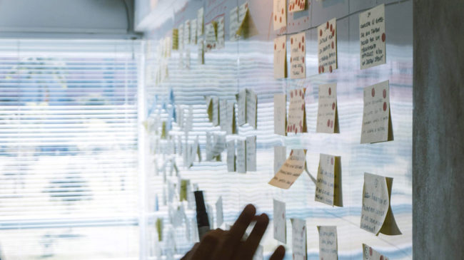 DIM Blog - Why a messaging strategy is worth the investment: Man brainstorming with sticky notes